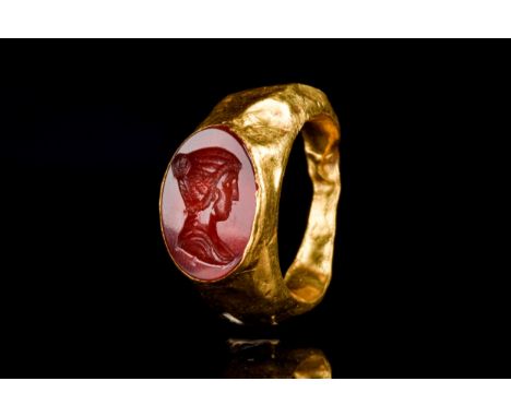 Ca. 100-300 AD A hollow gold ring composed of a round hoop with expanding shoulders and an oval bezel set with a carnelian in