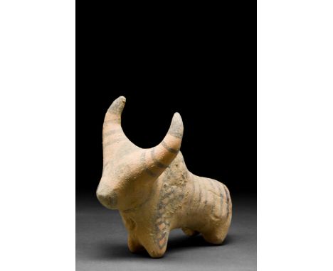 Ca. 3rd Millennium BC A creme-coloured ceramic figurine of a zebu bull with rondel eyes. Painted with stripes on the back, sh