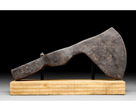 Ca. 900-1100 AD An iron axe head with a curved beard and cutting edge, narrow circular socket, and heavy hammer end. The blad