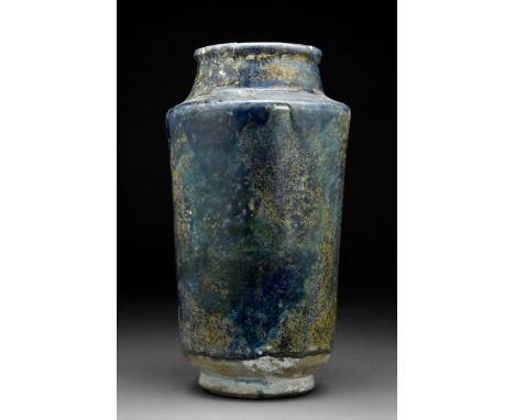 Kashan, Persia, Ca. 12th century AD A classic pottery albarello jar with layers of intense navy glaze. The vessel rises from 