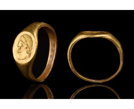 Ca. 100-300 AD A fine gold finger ring composed of a flat-section hoop widening to form a bezel engraved with a portrait of a