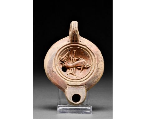 Ca. 1-200 AD A fine terracotta oil lamp of Loeschcke Type VIII, shoulder V. On the discus a dolphin in front of the rudder. R