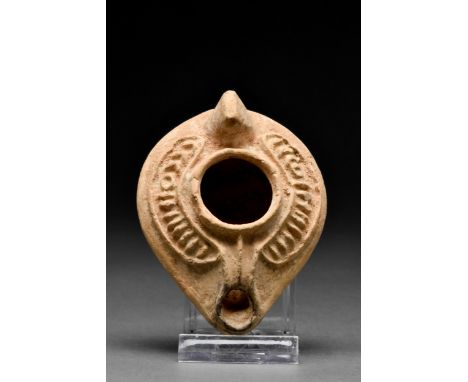 Ca. 100-300 AD A wonderfully preserved, mould-made terracotta oil lamp featuring a large, rounded body with a central pouring