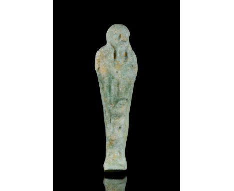 Late Period, Ca. 664-332 BC A light blue faience ushabti figure wearing a tripartite wig, a false beard, and holding a sheaf 