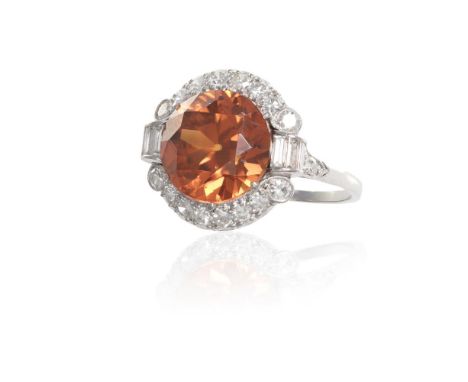 AN ART DECO ZIRCON AND DIAMOND RINGSet centrally with a circular-cut orange zircon, weighing approximately 6.20cts, within a 