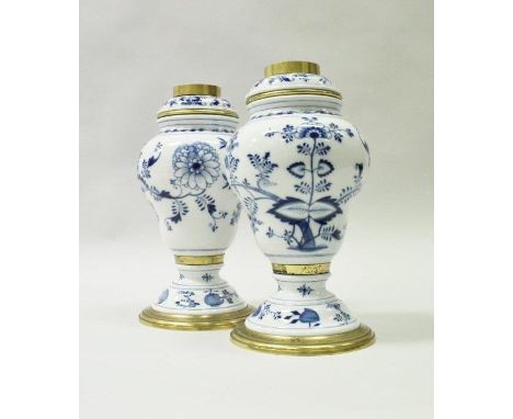 A pair of Meissen onion pattern blue and white inverted pear shaped oil lamp bases with brass mounted reservoirs bearing blue
