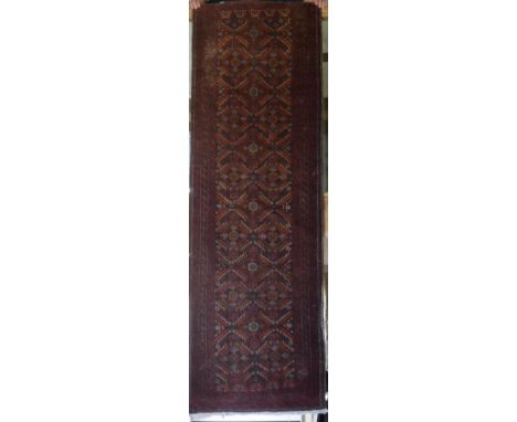 A Belouche runner, the central panel set with repeating geometric motifs on a dark brown ground within a stepped brown and re