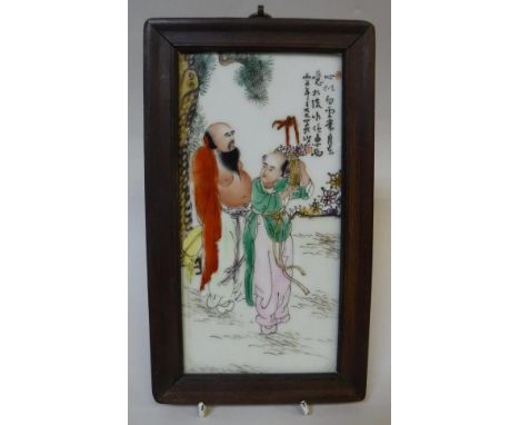 A Chinese polychrome decorated porcelain tile depicting two figures in a landscape with script, 28 cm x 16 cm