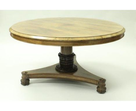 A 19th Century rosewood tilt-top breakfast table with canted edge on a turned and carved column to a platform tripod base, on