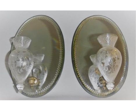 A pair of 19th Century mirrored back wall sconces, the oval cut decorated back with flower etched glass shaped bowls to the f