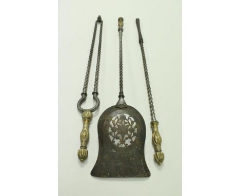 A set of three iron fireside tools with embossed brass handles, rope-twist bodies to include a shovel with pierced blade, a p