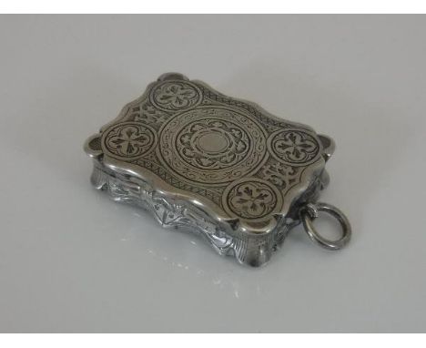 A Victorian silver vinaigrette of waisted rectangular form with engraved pattern to top and base, opening to reveal a gilt-wa