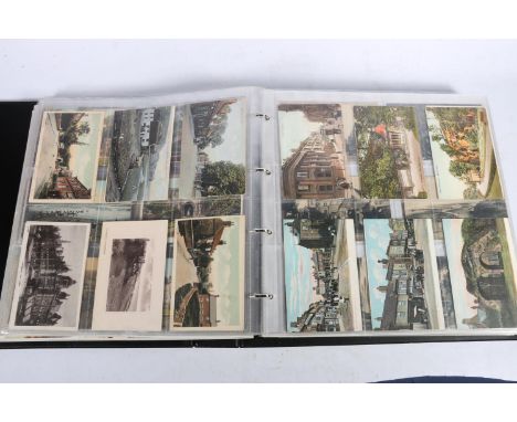 Large black ring binder album containing approximately 575 vintage postcards, mostly English topographical arranged by county