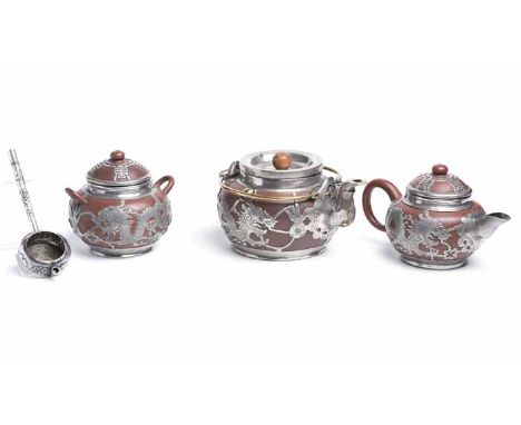 CHINESE WHITE METAL THREE PIECE OVERLAID EARTHENWARE TEA SET
decorated with dragons and stylised characters, stamped to base;