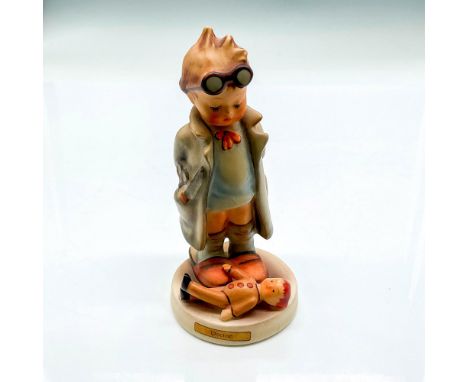Hand painted boy with goggles and lab coat overlooking a doll patient. Hummel backstamp W Germany. Impressed mark 127. Issued