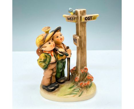 Hummel porcelain figure portraying a young boy standing at a crossroads, a halt sign beside him. The boy gazes down the road,