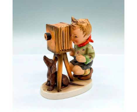 Hand painted figure of a young boy behind an old timey camera with a dog underneath. Goebel backstamp. Artist: M.I. HummelIss