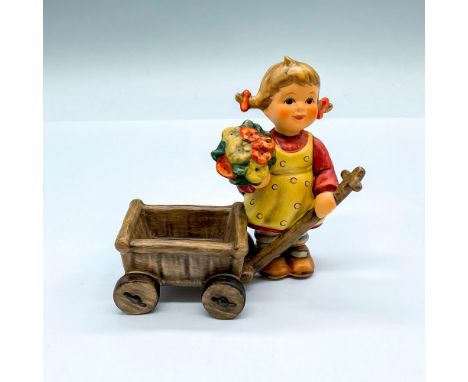 Hand painted figure of a young girl holding a wagon and potted plant. Goebel backstamp. Artist: M.I. HummelIssued: 2001Dimens