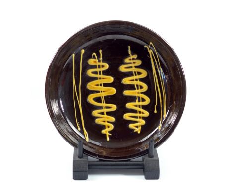 MICHAEL SHONE (born 1938); a slipware dish with trailed decoration, impressed M and RCA marks, diameter 33.5cm.&nbsp;(D)

Mad