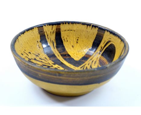 PETER WRIGHT (1919-2003); an early small stoneware bowl covered in yellow and black glaze with incised decoration, incised 'M