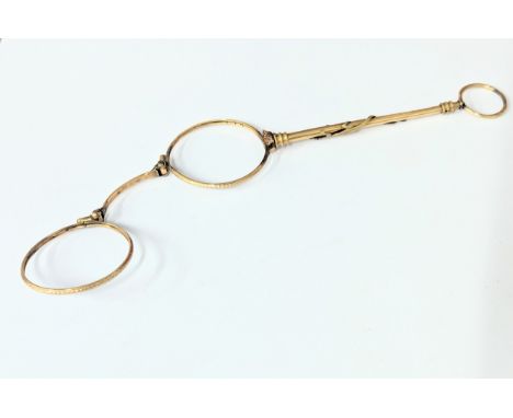 An ornate 19th Century rolled gold lorgnette with decorative lizard and garnet eyes 