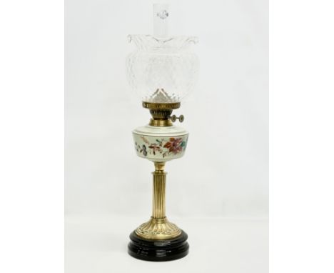 A large Victorian double burner oil lamp. With hand painted glass bowl and brass reeded column. 69cm 