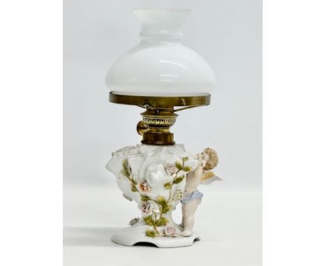 A Late 19th/Early 20th Century German porcelain oil lamp. With Cupid and crusted flower decoration. 30cm 