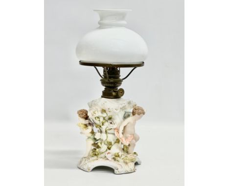 A Late 19th/Early 20th Century German porcelain oil lamp. With cupids and crusted flower decoration. 37cm 