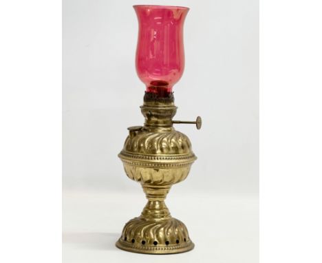 A Late 19th Century brass oil lamp with later ruby glass shade. 39cm 