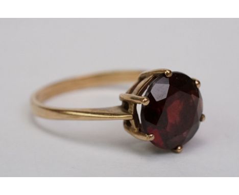 Garnet 9ct yellow gold ring, the round mixed cut garnet diameter approx 10mm, claw setting, tapered shoulders, ring size O½ 