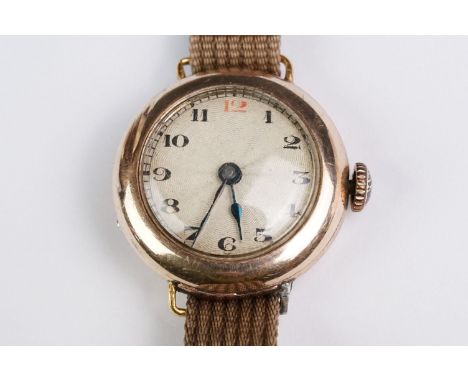 Early 20th century 9ct rose gold cased wristwatch, engine turned silvered dial, black and red Arabic numerals, black poker ha