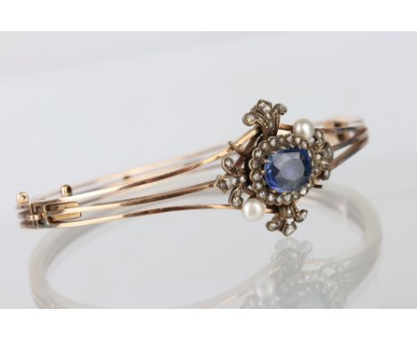 Edwardian sapphire, pearl and diamond 14ct rose gold hinged bangle, the oval mixed cut blue sapphire measuring approx 7mm x 9
