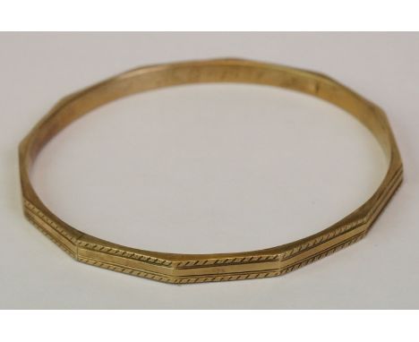 9ct yellow gold slave bangle, faceted form with engraved repeating decoration, the inner bangle engrave MC 1925, width approx