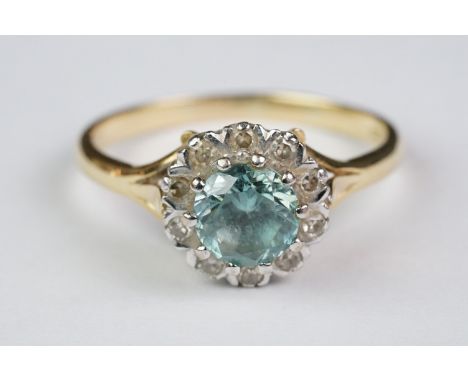 Blue topaz and diamond 18ct yellow gold and white gold set cluster ring, the round mixed cut topaz diameter approx 6mm, claw 