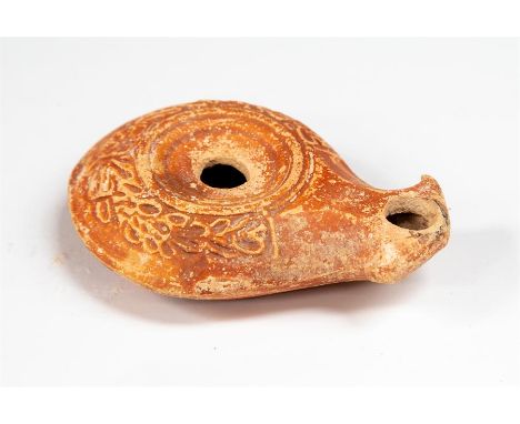 Roman Early Oil Lamp with Volute Nozzle, C. 1st Century AD.   An early Roman oil lamp in buff clay with reddish-brown slip; w