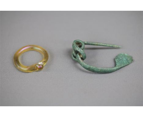 Roman Brooch and Ring Group, 1st-3rd century AD.    A pair of items including a bronze dolphin brooch and a glass ring with c