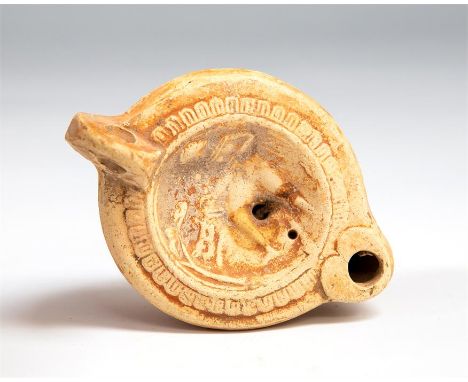 Roman oil lamp with hunter and bear, 1st century AD.   A terracotta oil lamp with heart shaped nozzle, oval body with series 