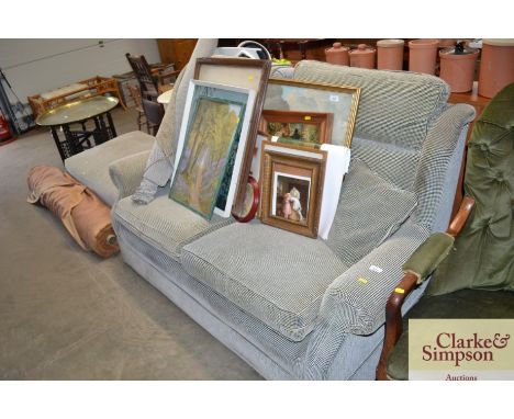 A reupholstered two seater settee with matching pouffe and roll of spare material