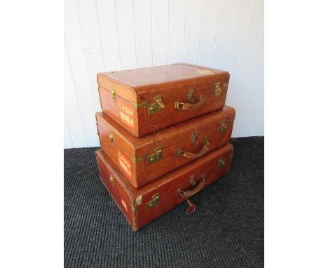 A set of three graduated leather vintage suitcases