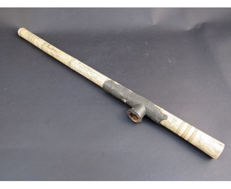 A 19th Century oriental bone  turned sectional pipe with embossed metal mount with all over imagery of figures, foliage and f