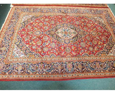 A modern red ground Persian design carpet approximately 298cm x 200cm