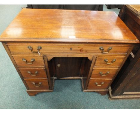 A George III mahogany kneehole desk or dressing table, late 18th/early 19th century, the bevelled rectangular top above a sha