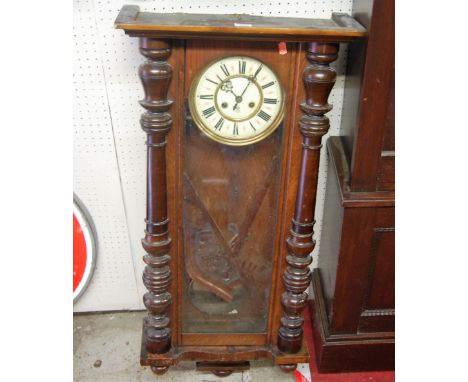 A circa 1900 walnut cased Vienna drop trunk wall clock, having a cream enamel circular dial with pendulum, height 102cm