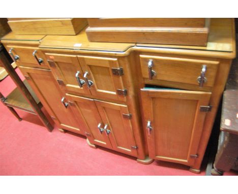 An Art Deco walnut ledgeback breakfront sideboard, fitted with an arrangement of twin frieze drawers and six recessed panelle