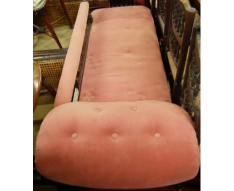 An Edwardian walnut and pink button back upholstered chaise longue