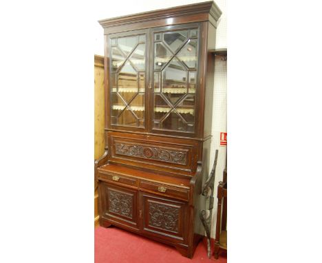 An Edwardian carved walnut secretaire bookcase, having twin bevelled and astragal glazed upper doors over fall front fitted c