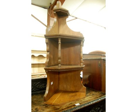 An Edwardian walnut two-tier hanging open corner shelf