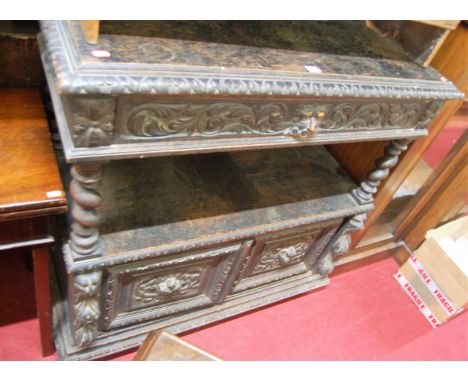 A late 19th century heavily carved and ebonised oak ledgeback two-tier buffet whatnot, having Green Man mask carved single lo