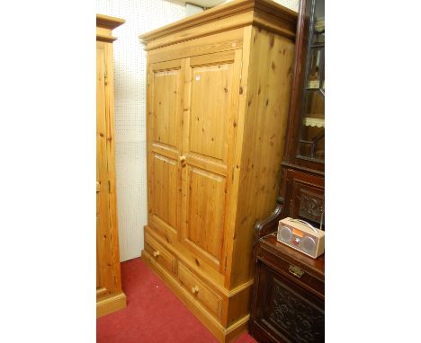 A modern pine double door wardrobe having twin lower drawers, width 123cm