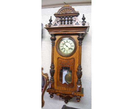 A late 19th century figured walnut Vienna regulator, having an enamelled circular dial within part glazed trunk door with pen